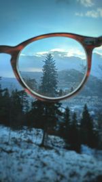 Reflection of trees on snow covered landscape