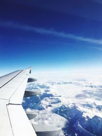 Aerial view of aircraft wing over landscape against sky