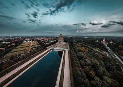 High angle view of city buildings against cloudy sky