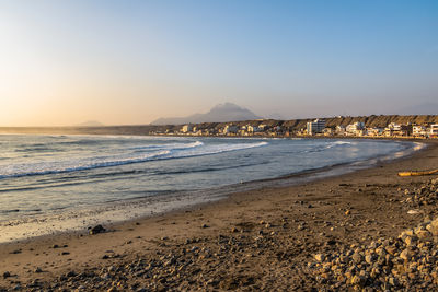 Scenic view of beach against clear sky during sunset