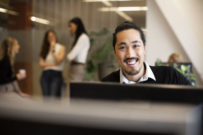 Portrait of smiling businessman working in office