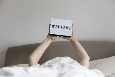 Portrait of woman with text on bed at home