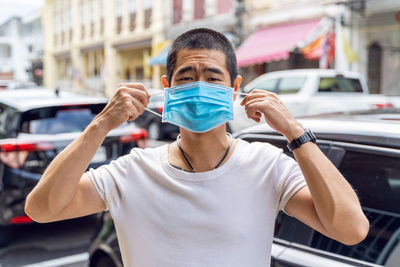 Portrait of man wearing sunglasses standing on street in city