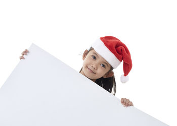 Portrait of smiling girl holding umbrella against white background