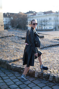 Side view of young woman walking on footpath