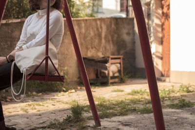 Side view of woman sitting on land