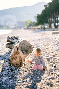 Full length of boy sitting on land