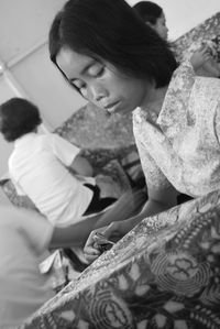 Mature woman doing design on batik at home