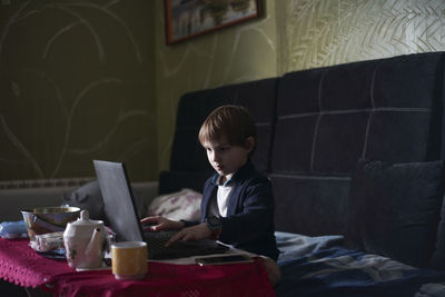 Boy sitting on table at home