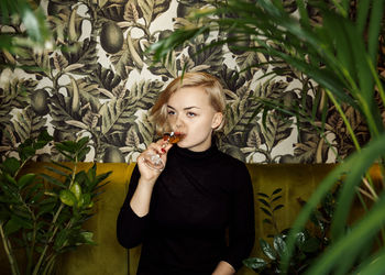 Portrait of young woman holding plants