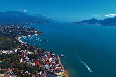 High angle view of city by sea against sky