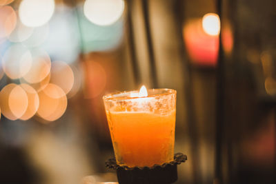 Close-up of lit candles on glass