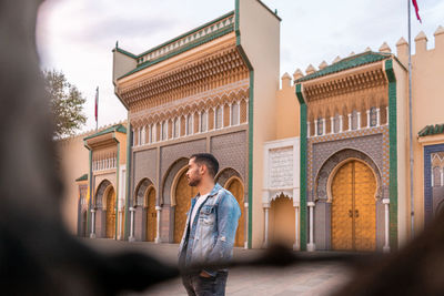 Rear view of woman standing against building