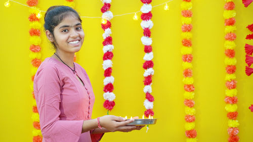 Portrait of young india woman with diya-oil lamp. diwali festival or ganesh chaturthi celebration