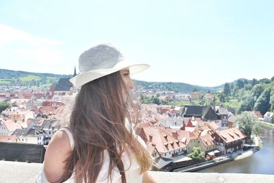 Beautiful young woman in city against clear sky