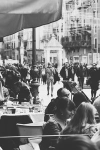 People on city street against buildings