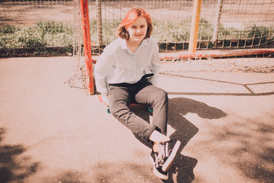 Portrait of smiling young woman sitting on seat