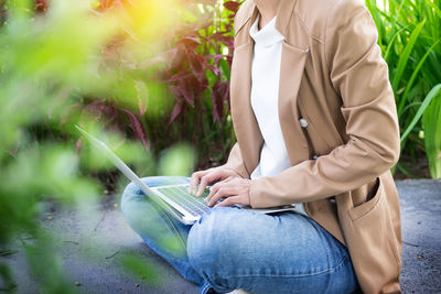 Midsection of woman using mobile phone