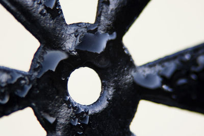 Close-up of hand holding object over white background