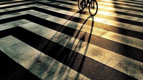 Low section of person riding bicycle on zebra crossing