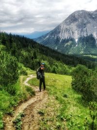 Rear view of man on mountain against sky