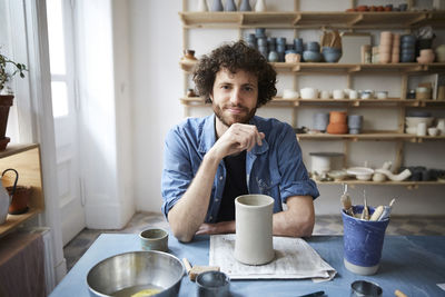 Portrait of mid adult man sitting in pottery class