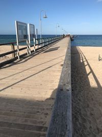 Wooden posts on beach against sky