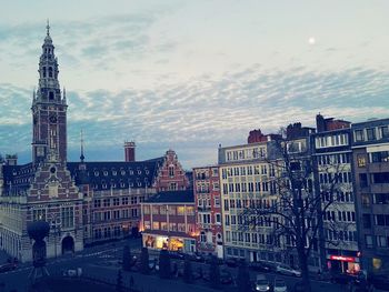 Buildings in city against cloudy sky