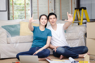 Portrait of smiling young couple sitting on sofa