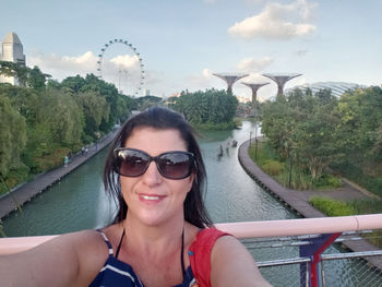 Portrait of smiling woman in sunglasses against sky