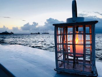 Built structure on sea against sky at sunset