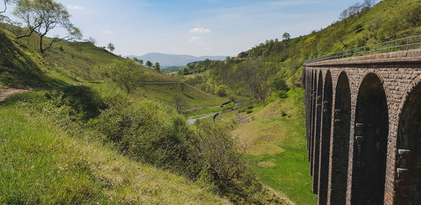 Scenic view of landscape and viaduct against sky