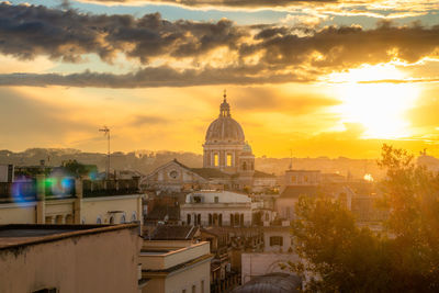 Buildings in city against sky during sunset