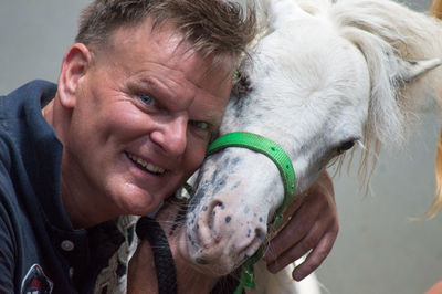 Portrait of happy man with pony