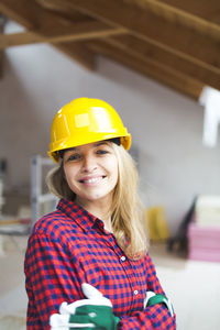 Portrait of smiling woman standing at construction site
