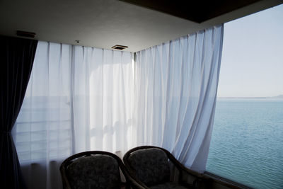 View of the sea against sky seen through a window in ryokan, a traditional style hotel in japan.