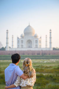 Rear view of couple kissing against sky