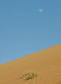 Scenic view of desert against clear blue sky