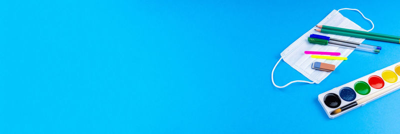 High angle view of multi colored paper against blue background