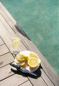 Close-up of drink and fruits at a pool 