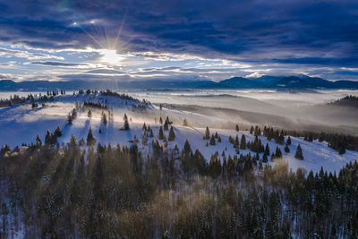 Scenic view of snow covered landscape against sky during sunset