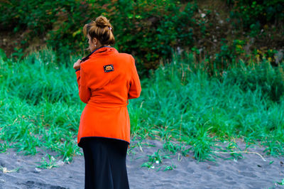 Rear view of woman standing on grass