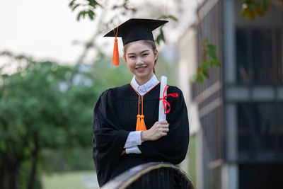 Portrait of a smiling young woman holding camera