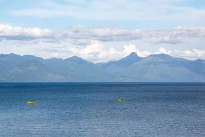 Scenic view of sea and mountains against sky