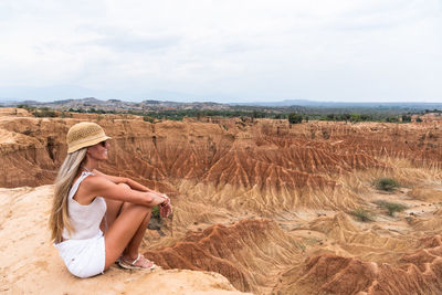 Rear view of woman standing on field against sky