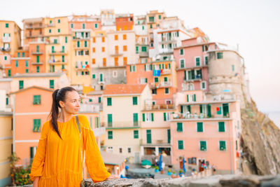 Full length of woman standing against buildings in city