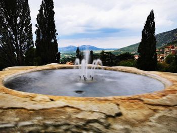 Fountain in lake against sky