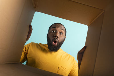 Directly below portrait of man looking at cardboard box
