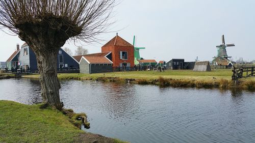 Houses by lake against sky