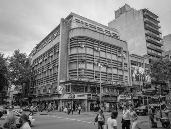 Group of people on road against buildings in city